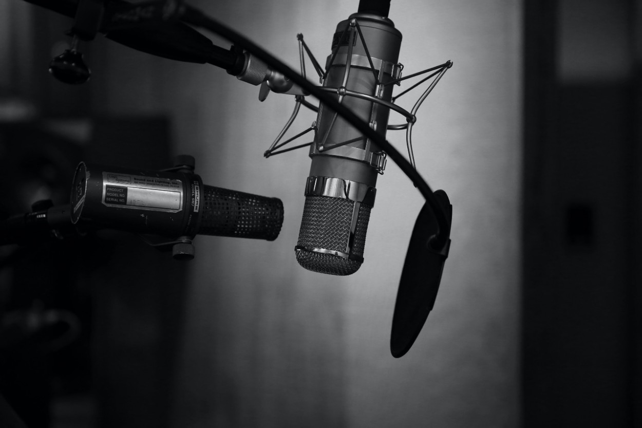 Third Culture Africa 7 Ways to use a Podcast for an entrepreneur podcast microphones with one having pop shield and facing up side down in a room with black background