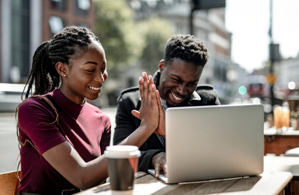 Third Culture Africans team success third culture africans a young lady and man congratulating one another in front of a laptop