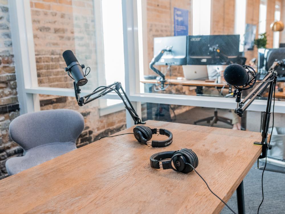 Third Culture Africa 4 things that make the best business podcast room with 2 large brown table with black speakers attached to the table and the black earphone connected to them with cables.